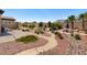 Serene backyard with lush landscaping, stone accents, winding walking paths, and comfortable seating at 4317 Velvet Ridge Ct, Las Vegas, NV 89129