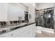Modern bathroom featuring a marble countertop, white cabinets, and a glass-enclosed shower at 4317 Velvet Ridge Ct, Las Vegas, NV 89129