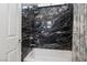 Bathroom with stylish marble walls, a modern showerhead, and decorative floral curtain at 4317 Velvet Ridge Ct, Las Vegas, NV 89129
