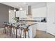 Bright kitchen featuring white cabinetry, stainless appliances, a marble countertop island with seating, and modern pendant lighting at 4317 Velvet Ridge Ct, Las Vegas, NV 89129