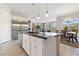 Open-concept kitchen with stainless steel appliances, granite countertops, and a view of the dining and living areas at 4317 Velvet Ridge Ct, Las Vegas, NV 89129