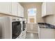 Bright laundry room with modern washer and dryer, granite countertop, and ample storage cabinets at 4317 Velvet Ridge Ct, Las Vegas, NV 89129