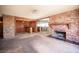 Living room featuring a brick fireplace, exposed wooden beams, and open access to adjacent rooms at 4516 E Flamingo Rd, Las Vegas, NV 89121