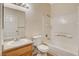 Bright bathroom with white tile tub, wood vanity, and large mirror with light fixture at 4730 E Craig Rd # 1005, Las Vegas, NV 89115
