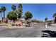 Gated community entrance with lush palm trees, signage, and secure access control at 4730 E Craig Rd # 1005, Las Vegas, NV 89115