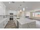Open-concept kitchen featuring white cabinetry, an island with marble countertop, and modern stainless appliances at 4801 Stoneham, Pahrump, NV 89061