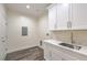 Laundry room with modern cabinets, sink, and new laminate flooring at 4801 Stoneham, Pahrump, NV 89061