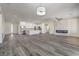 Open-concept living area with gray wood floors, modern fireplace, and kitchen with stainless steel appliances at 4801 Stoneham, Pahrump, NV 89061