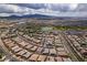 Expansive aerial view of a community featuring well-maintained homes, green spaces, and scenic mountain backdrop at 489 Intonation St, Henderson, NV 89011