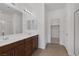 Bright bathroom with dual sinks, brown cabinets, and a glass-enclosed shower at 489 Intonation St, Henderson, NV 89011