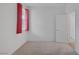 This bedroom has neutral carpeting, window with red curtains, and a white door at 489 Intonation St, Henderson, NV 89011