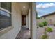 Inviting entrance with a covered walkway and brick pathway to the dark wood front door at 489 Intonation St, Henderson, NV 89011