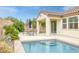 Beautiful backyard with a sparkling pool, covered patio, and lush green landscaping at 489 Intonation St, Henderson, NV 89011
