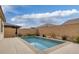 A refreshing swimming pool is surrounded by a concrete patio and brick wall in this backyard at 489 Intonation St, Henderson, NV 89011