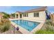 Secluded backyard featuring a swimming pool, rock landscaping, and comfortable patio seating area at 489 Intonation St, Henderson, NV 89011