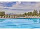 Community pool with lounge chairs, offering a relaxing oasis with mountain views in the distance at 489 Intonation St, Henderson, NV 89011