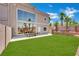 Lush backyard featuring green grass, a dining area and an elegant home exterior at 5015 Thunder River Cir, Las Vegas, NV 89148