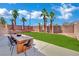 Spacious backyard with a patio area, tall palms, well-maintained grass, and perimeter wall at 5015 Thunder River Cir, Las Vegas, NV 89148