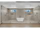 Luxurious bathroom featuring a soaking tub centered between dual walk-in showers with glass enclosures at 5015 Thunder River Cir, Las Vegas, NV 89148