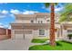 Beautiful two-story stucco home with a two-car garage, well-manicured lawn, and desert landscaping with blue skies at 5015 Thunder River Cir, Las Vegas, NV 89148