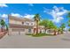 Two-story stucco home with a two-car garage, desert landscaping, palm trees, and a circular driveway on a sunny day at 5015 Thunder River Cir, Las Vegas, NV 89148