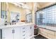 Bathroom featuring double sinks, a vanity, and a tub with a shower behind a glass enclosure at 5058 Crooked Stick Way, Las Vegas, NV 89113