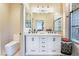 Modern bathroom with double sinks and large mirrors, a glass shower, and a separate toilet at 5058 Crooked Stick Way, Las Vegas, NV 89113