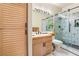 Bathroom with modern wood vanity and a contemporary shower with decorative tile work at 5058 Crooked Stick Way, Las Vegas, NV 89113