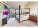 Spacious bedroom with a four-poster bed, a TV, and sliding doors to a private patio at 5058 Crooked Stick Way, Las Vegas, NV 89113