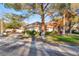 Well-maintained property featuring lush green grass, mature shade trees and lovely red outdoor seating at 5058 Crooked Stick Way, Las Vegas, NV 89113