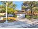 Charming home featuring manicured landscaping, a two-car garage, and a classic tiled roof at 5058 Crooked Stick Way, Las Vegas, NV 89113