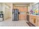 Well-lit kitchen features stainless steel appliances, wood cabinets, and tile flooring at 5058 Crooked Stick Way, Las Vegas, NV 89113