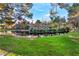 Scenic view of a home overlooking a serene pond surrounded by lush greenery and mature trees at 5058 Crooked Stick Way, Las Vegas, NV 89113
