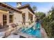 Serene backyard featuring a small pool and jacuzzi with travertine tile and lush landscaping providing privacy at 51 Avenida Sorrento, Henderson, NV 89011