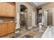 Bathroom with a large soaking tub, shower with tiled walls and floor, and wooden cabinets at 51 Avenida Sorrento, Henderson, NV 89011