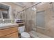 Bathroom with beige tile shower, glass doors, and vanity with marble countertop at 51 Avenida Sorrento, Henderson, NV 89011