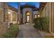 Elegant front entrance featuring a stone turret, archway, manicured landscaping, and a paver walkway leading to the front door at 51 Avenida Sorrento, Henderson, NV 89011