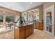 Kitchen island with granite countertop, barstool seating, and view of the breakfast nook and backyard at 51 Avenida Sorrento, Henderson, NV 89011