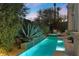 Ambient pool and spa area at twilight with waterfall features and lush landscaping, creating a tranquil and private escape at 51 Avenida Sorrento, Henderson, NV 89011