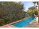 Beautiful backyard featuring a pool, lush greenery providing privacy, and desert landscaping, ideal for summer fun at 51 Avenida Sorrento, Henderson, NV 89011
