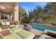 Inviting pool area with comfortable outdoor seating, a fire pit, and lush greenery, perfect for relaxing and entertaining at 51 Avenida Sorrento, Henderson, NV 89011