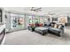 Spacious living room with large sectional, plush carpet, and lots of natural light from several windows at 5976 Rockway Glen Ave, Las Vegas, NV 89141