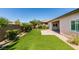 This backyard is complete with green lawn, a brick patio, desert landscaping, and lush shrubbery at 6085 Ryan Ranch Ave, Las Vegas, NV 89130