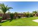 Green lawn, palm trees, privacy landscaping, and a brick wall enhance this beautiful backyard at 6085 Ryan Ranch Ave, Las Vegas, NV 89130