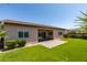 The manicured backyard features a brick patio, green lawn, desert landscaping, and ample sunlight at 6085 Ryan Ranch Ave, Las Vegas, NV 89130