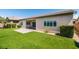 A manicured green lawn, brick patio, desert landscaping, and lush shrubbery enhance this backyard at 6085 Ryan Ranch Ave, Las Vegas, NV 89130