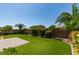 Beautiful backyard features manicured green lawn, palm trees, and a brick patio for outdoor relaxation at 6085 Ryan Ranch Ave, Las Vegas, NV 89130