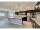 Modern kitchen featuring stainless steel appliances, an island with granite countertops and dark wood cabinets at 6085 Ryan Ranch Ave, Las Vegas, NV 89130