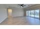 Bright open living space with a ceiling fan, wood-look flooring, and backyard views at 6085 Ryan Ranch Ave, Las Vegas, NV 89130