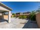 Backyard view featuring a covered patio, concrete area, and block wall fencing with planted shrubs and trees at 6442 Kobe Knoll Ct, Las Vegas, NV 89141